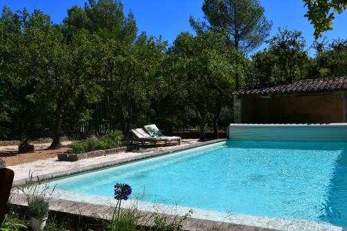une piscine dans une cour avec une maison dans l'établissement La Piscine dans la Foret, à Gordes