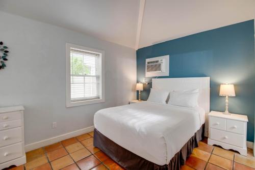 a bedroom with a large bed with a blue wall at Osprey Suite - Southernmost Sanctuary in Key West