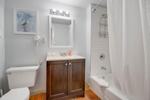 a bathroom with a toilet and a sink and a shower at Osprey Suite - Southernmost Sanctuary in Key West