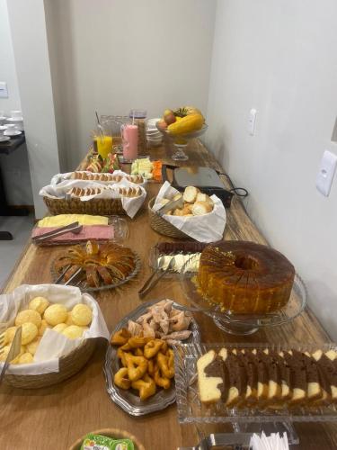 a table topped with lots of different types of food at Rio Jordao Hotel in Siderópolis