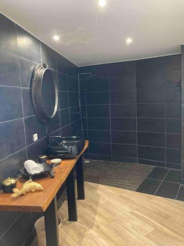 La salle de bains est pourvue de carrelage bleu et d'une table en bois. dans l'établissement Location à Porto Vecchio, à Porto-Vecchio