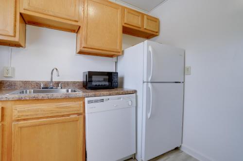 a kitchen with a white refrigerator and a sink at Prime Alexandria Location Corporate Apt in Alexandria