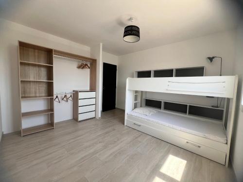 - une chambre avec des lits superposés blancs et des étagères dans l'établissement maison avec piscine à débordement, à Saint-Géniès-de-Malgoirès