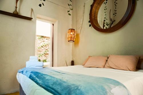 Un dormitorio con una cama y un espejo y una ventana. en Casona enfrente del Santuario 3, en Guadalajara