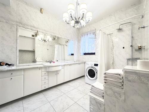 a white bathroom with a sink and a washing machine at Villa with outdoor pool Warsaw in Magdalenka