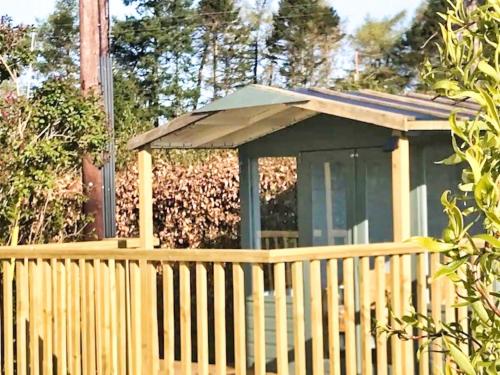 a wooden privacy fence with a gazebo at Ford Common - Bungalow - Sleeps 6 - Stunning Walks and Views - Dog Friendly - 2 Bedrooms 2 Bathrooms Cottage - Sun Room - Private Garden - Off Street Parking - Quiet Rural Location - Fast Wifi in Ford
