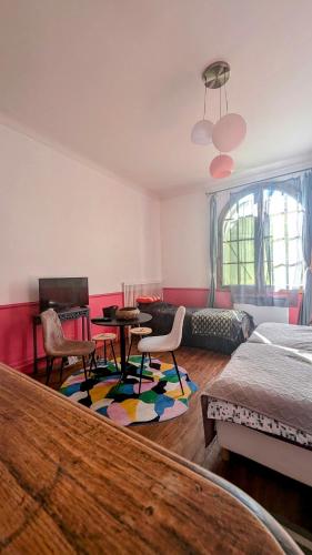 un salon avec un lit, une table et des chaises dans l'établissement L Entre Deux chambres d hôtes, à Belin-Beliet