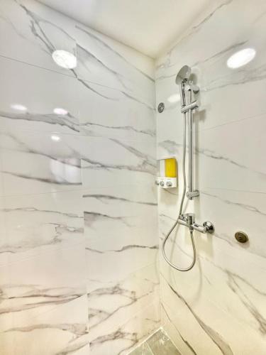 a bathroom with a shower with marble tiles at Comfy 2BR City Center Condo in Los Prados
