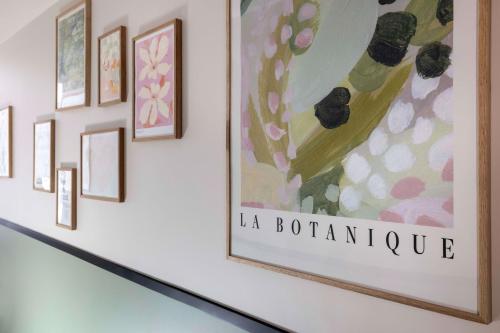 a group of framed art on a wall at Hotel Grand Coeur Latin in Paris