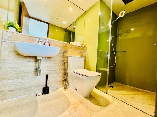 Un baño con un inodoro blanco y un lavabo. en KLCC Vortex Suites Residence, en Kuala Lumpur