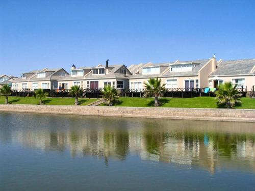 a row of houses next to a body of water at Lalandi Unit 14 - Beach Cottage - Langstrand in Langstrand