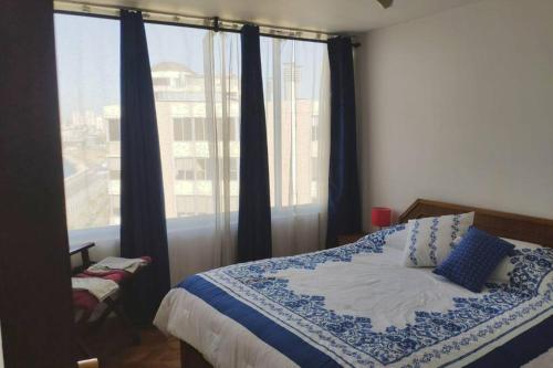 a bedroom with a bed and a large window at La mejor vista de la bahía de valparaíso in Valparaíso