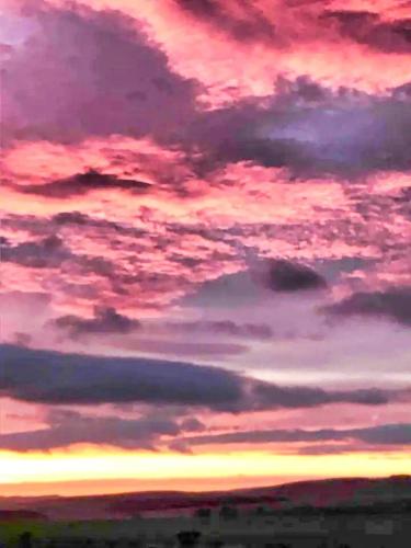 a sunset with clouds in the sky at Ford Common - Bungalow - Sleeps 6 - Stunning Walks and Views - Dog Friendly - 2 Bedrooms 2 Bathrooms Cottage - Sun Room - Private Garden - Off Street Parking - Quiet Rural Location - Fast Wifi in Ford