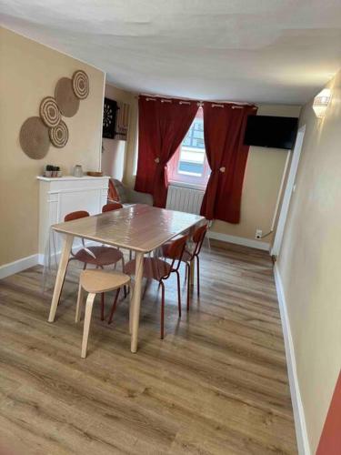 a dining room table and chairs in a room at Appart centre ville in La Loupe