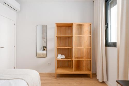 a room with a wooden book shelf in a bedroom at Live It Malaga in Málaga