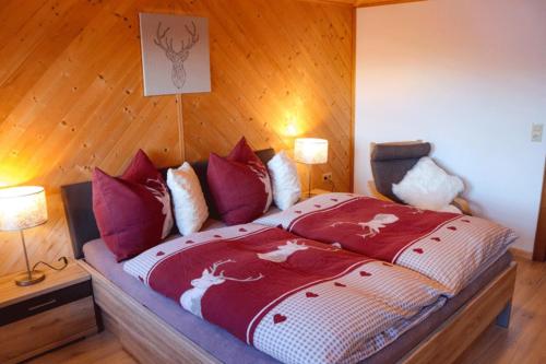 Un dormitorio con una cama con edredón rojo y caballos. en Arishorst Aussergasteighof, en Weerberg