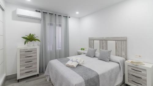 a white bedroom with a bed and a dresser at El Soberano El Gastor by Ruralidays in El Gastor
