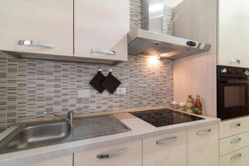 a kitchen with a sink and a stove at Aeroporto Ciampino - Casa Kennedy in Ciampino