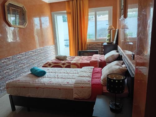 a bedroom with two beds and a window at superbe appartement Al Mansouria-les jardins de l'Atlantique in Pont Blondin