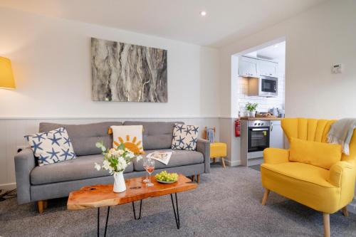 a living room with a couch and two chairs at Sunnybeach Holiday Apartments in Paignton