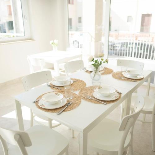 a white dining room table with white chairs and a white table and chairsktop at Crial Retreat in Falerna
