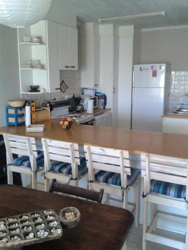 a kitchen with a wooden table and a refrigerator at Lalandi Unit 14 - Beach Cottage - Langstrand in Langstrand
