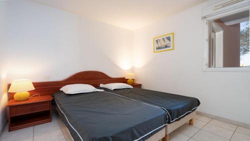 une chambre avec un lit et deux lampes et une fenêtre dans l'établissement PALMYRA GOLF - 112 - 4 Pers, au Cap d'Agde