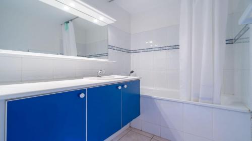 une salle de bain avec un lavabo bleu et un miroir dans l'établissement PALMYRA GOLF - 112 - 4 Pers, au Cap d'Agde