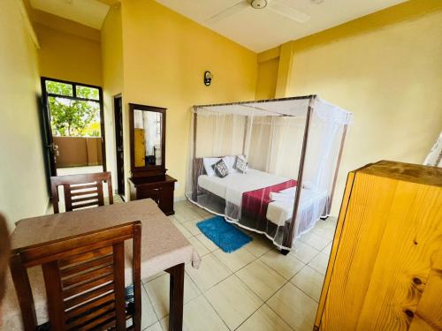 a bedroom with a bed with a canopy in it at New Golden Bay Resort Weligama in Weligama