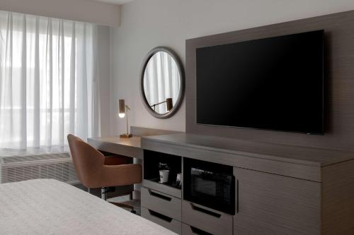 a hotel room with a flat screen tv and a bed at Hampton Inn By Hilton Winnipeg Downtown in Winnipeg