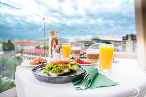 a table with a plate of food and glasses of beer at Simfonia Boutique Hotel in Râmnicu Vâlcea