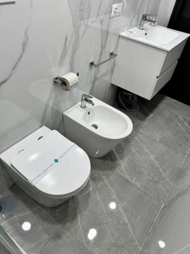 a white bathroom with a toilet and a sink at Il Ritrovo Spa&Rooms in Naples