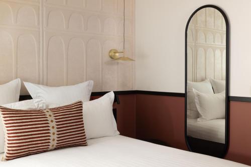 a bedroom with a bed and a mirror at Hotel Grand Coeur Latin in Paris