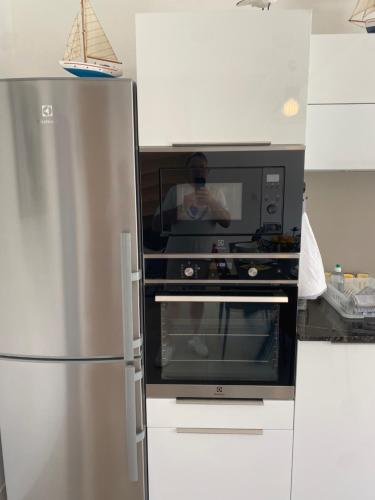 a kitchen with a microwave and a refrigerator at SixTer in La Guérinière