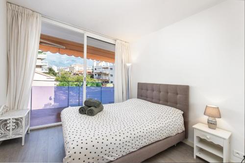 - une chambre avec un ours en peluche sur un lit et une fenêtre dans l'établissement AIGLON - Agréable 2 pièces - 50 m du bord de mer, à Roquebrune-Cap-Martin