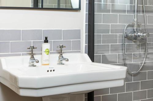 a white sink in a bathroom with a shower at The Stag at Stow in Stow on the Wold