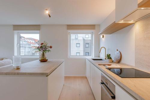 een keuken met een spoelbak en een aanrechtblad bij Huswell - Luxurious apartment on top location in Knokke in Knokke-Heist