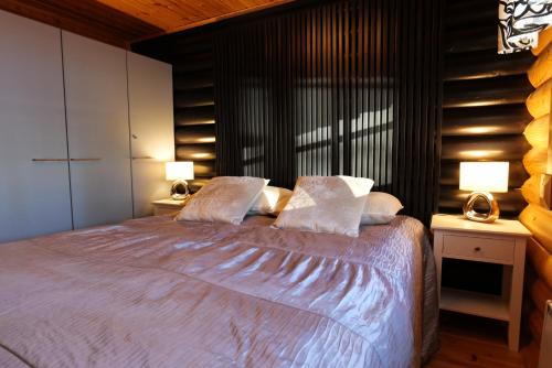 a bedroom with a bed with two lamps on two tables at Vernetti 1 Koli in Kolinkylä