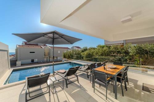 a patio with a table and chairs and a pool at Villa Nova Excellence 1, villa with private pool in Novalja