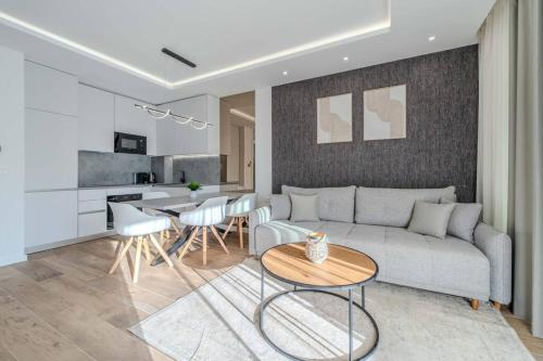 a living room with a couch and a table at Villa Nova Excellence 1, villa with private pool in Novalja