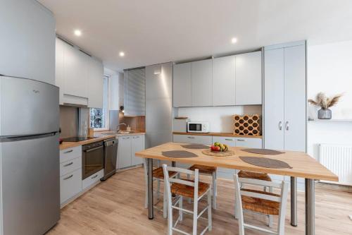 une cuisine avec une table en bois et des armoires blanches dans l'établissement #HF La Gare aux 400 Couverts Station GEM Tramway, à Grenoble