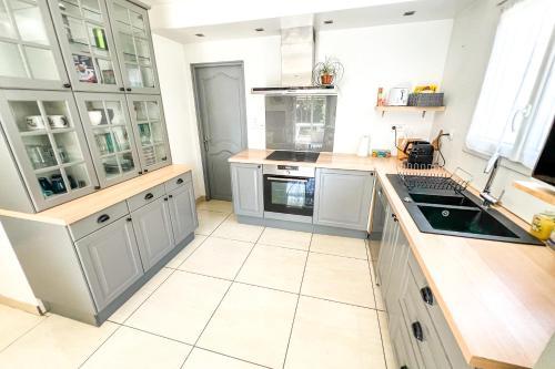 Il comprend une cuisine avec des placards blancs et du carrelage blanc. dans l'établissement AC - Car parking - Garden - Near Ramparts, à Avignon