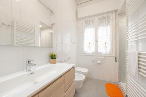 Un baño blanco con lavabo e inodoro. en Tatiana Flat - 10 minutes to Venice - Mestre Train Station - Free Parking, en Venecia