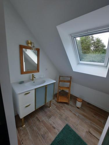 une salle de bain avec un lavabo, un miroir et une fenêtre dans l'établissement Charmante maison au cœur de la forêt, à Baguer-Morvan
