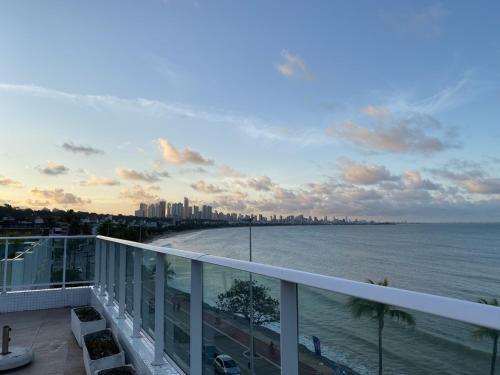 a balcony with a view of the ocean and a city at Blue Sunset Suites in Penha