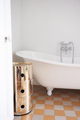 La salle de bains est pourvue d'une baignoire blanche. dans l'établissement Suite haussmannienne en Sologne, à Vierzon