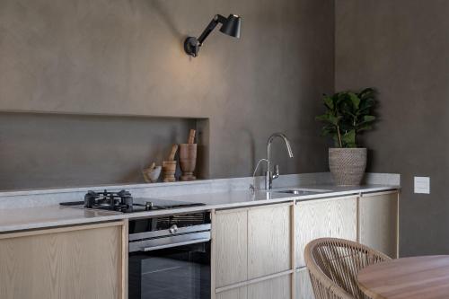 a kitchen with a sink and a stove at Romansbaai Collection in Gansbaai