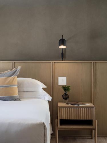 a bedroom with a bed and a side table with a lamp at Romansbaai Collection in Gansbaai