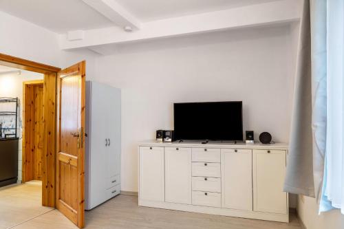 a living room with a television on a white dresser at Ferienwohnung Bernoth in Erfurt
