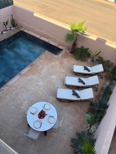 an overhead view of a table and chairs next to a pool at Villa Palms de l'Atlas in Marrakech